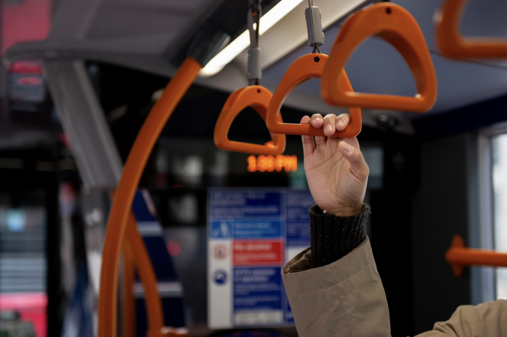 A woman holds on to a security knob in public transportation.